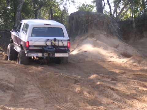 2006 Ford F-150 - SUV with large tires navigates a sandy incline during an off-road excursion.