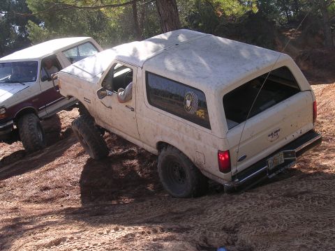 2006 Ford F-150 - Two 4x4 trucks, a Ford Bronco and an F-150, navigate a steep dirt trail.