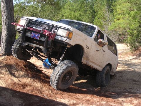 2006 Ford F-150 - An off-road SUV navigates a steep dirt path, its tires digging into the loose soil.