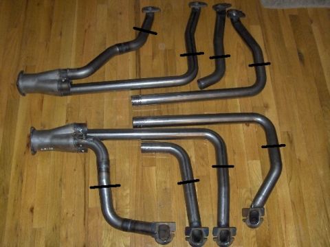 1990 Ford Mustang - Exhaust headers laid out on a wooden floor, with black marks indicating specific points.