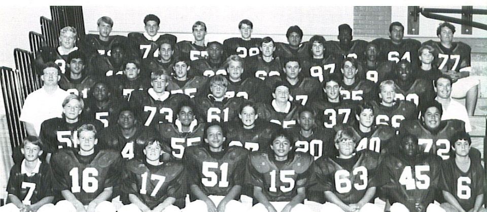 Black-and-white team photo of a football squad in dark jerseys