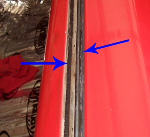 1978 Ford Bronco - Detail of a red vehicle's door seal, with arrows highlighting the gasket and frame.
