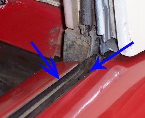 1978 Ford Bronco - Close-up of a red vehicle's cowl and door-jamb area with two blue arrows drawn on the photo pointing at the joint where the fender top meet…