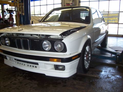 1992 Mercury Grand Marquis - White BMW E30 coupe on a lift in a garage, hood is open.