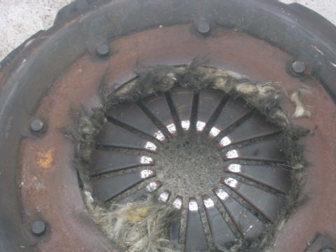 1990 Ford Bronco - A worn clutch disc shows significant fraying and damage to its friction material.