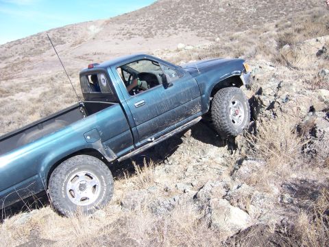 1995 Toyota Hilux - Toyota Hilux navigating difficult rocky terrain on a sunny day.