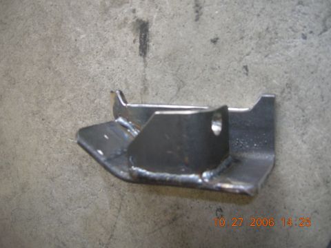 1996 Ford Bronco - A close-up view of a custom-welded metal bracket resting on a concrete surface.