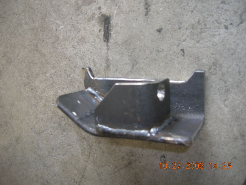 Fabricated bare steel suspension bracket with welded gusset on a concrete floor