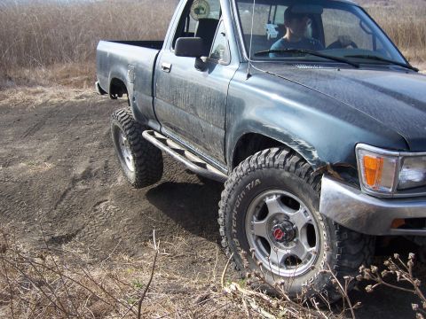 1995 Toyota Hilux - This pickup truck is equipped with off-road tires and side steps, suggesting it is used for off-road adventures.