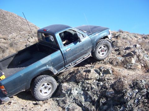 1995 Toyota Hilux - This 1995 Toyota Hilux navigates a challenging rocky trail under a clear blue sky.
