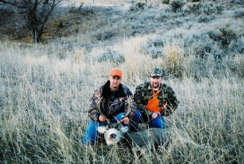 1996 Ford Bronco - Two hunters pose with their kill in a field of dry grass, with a "Supermotors.net" watermark in the lower right corner.
