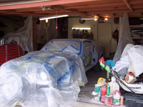 1971 Ford Mustang - A 1971 Ford Mustang is covered in plastic sheeting and tape, ready for a paint job in a cluttered garage.