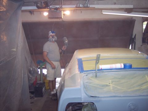 1971 Ford Mustang - Car body covered in masking tape and plastic sheeting, ready for spray painting in a garage.