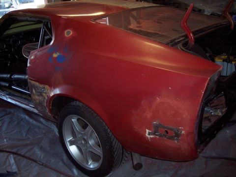 1971 Ford Mustang - This vehicle is undergoing bodywork and appears to be in a state of repair, with visible rust and primer.