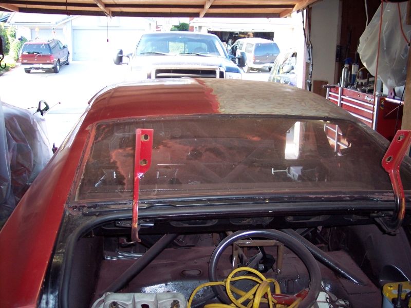 Red car trunk open, showing interior and rear window with red hood latches