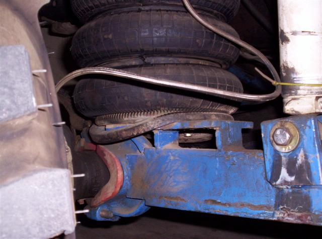 Blue painted suspension component with dual air bags and metal lines