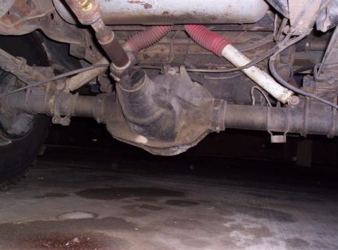 1995 Ford Bronco - Underside view shows the rear axle, driveshaft, and suspension parts of a vehicle.