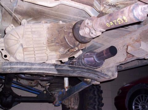 1995 Ford Bronco - The underside of a vehicle, including the transmission and driveshaft, with another vehicle partially visible in the background.