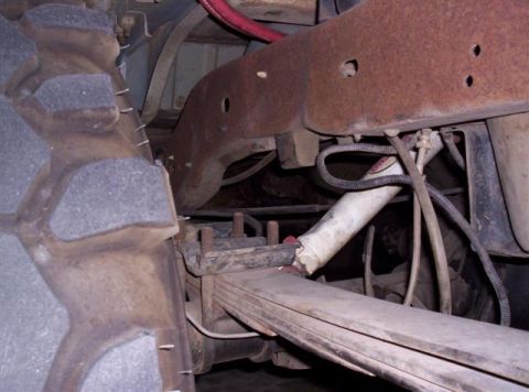 1995 Ford Bronco - Undercarriage view showing a large tire, leaf springs, and suspension components.