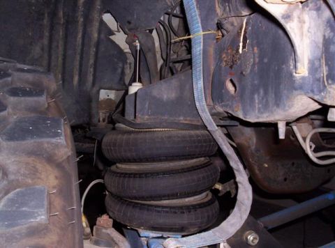1995 Ford Bronco - Close-up view of the air suspension system and a large tire, showing mechanical components.