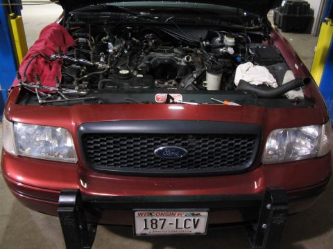 2001 Ford Crown Victoria - Front view of a red 2001 Ford Crown Victoria with its hood open, revealing the engine compartment.