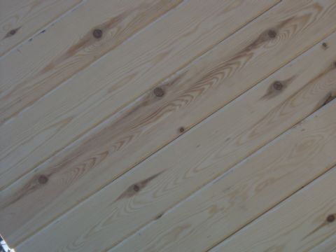 1990 Ford Bronco - The image shows a close-up of light-colored wood paneling with visible knots and grain patterns.