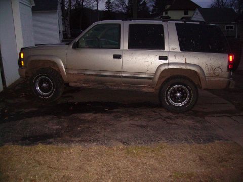 2000 Chevrolet Tahoe - This 2000 Chevrolet Tahoe is parked on a dirt driveway, showing its side profile with mud on the body.