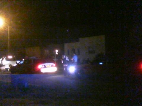 1989 Ford Bronco - Night scene with two individuals and a motorcycle under bright lights.