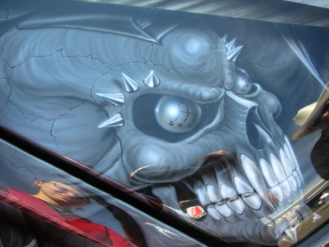 1998 Ford Crown Victoria - close-up of glossy airbrushed paintwork showing a fanged gray skull with spiked details.