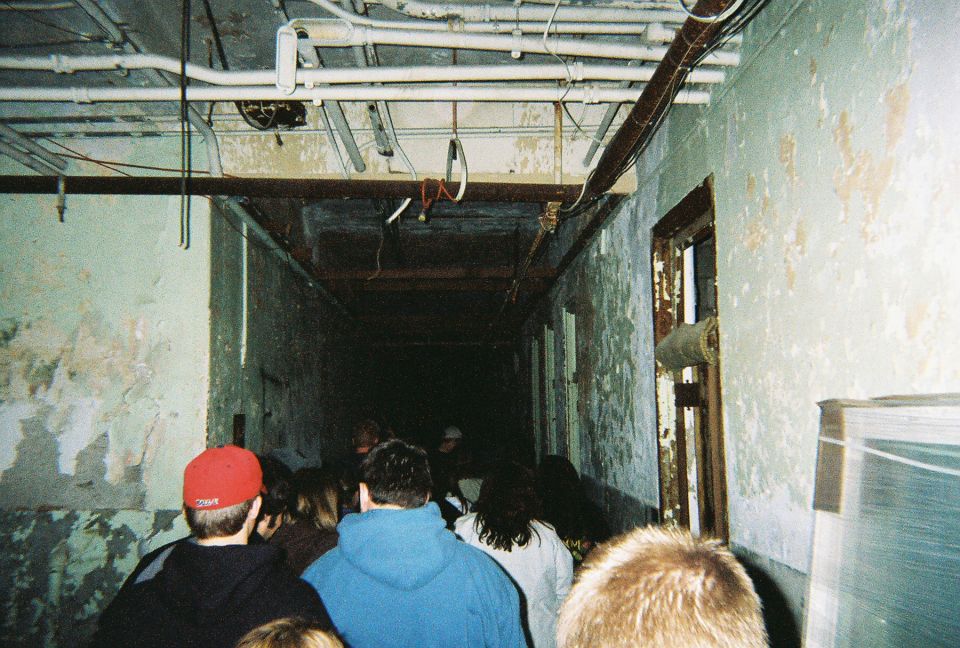 Group of people walking through a derelict building hallway