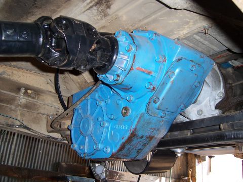 1983 Ford Bronco - Underside view of a vehicle's blue transfer case and driveshaft assembly.