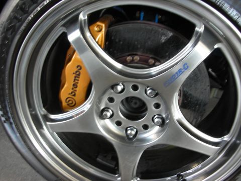 1998 Ford Crown Victoria - close-up of a silver five-spoke wheel with a polished lip, a yellow Brembo brake caliper, and a slotted rotor.