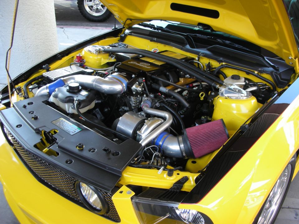 Yellow car engine bay with supercharger and red cone air filter
