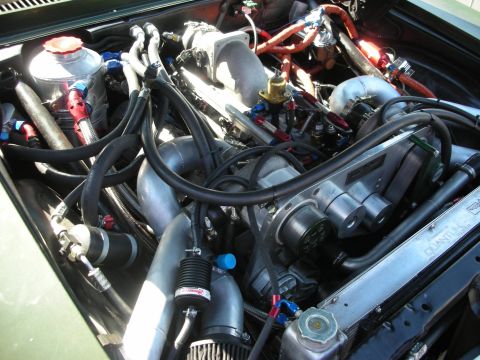1998 Ford Crown Victoria - heavily built engine bay packed with braided steel lines, anodized fittings, and a turbo or supercharger.