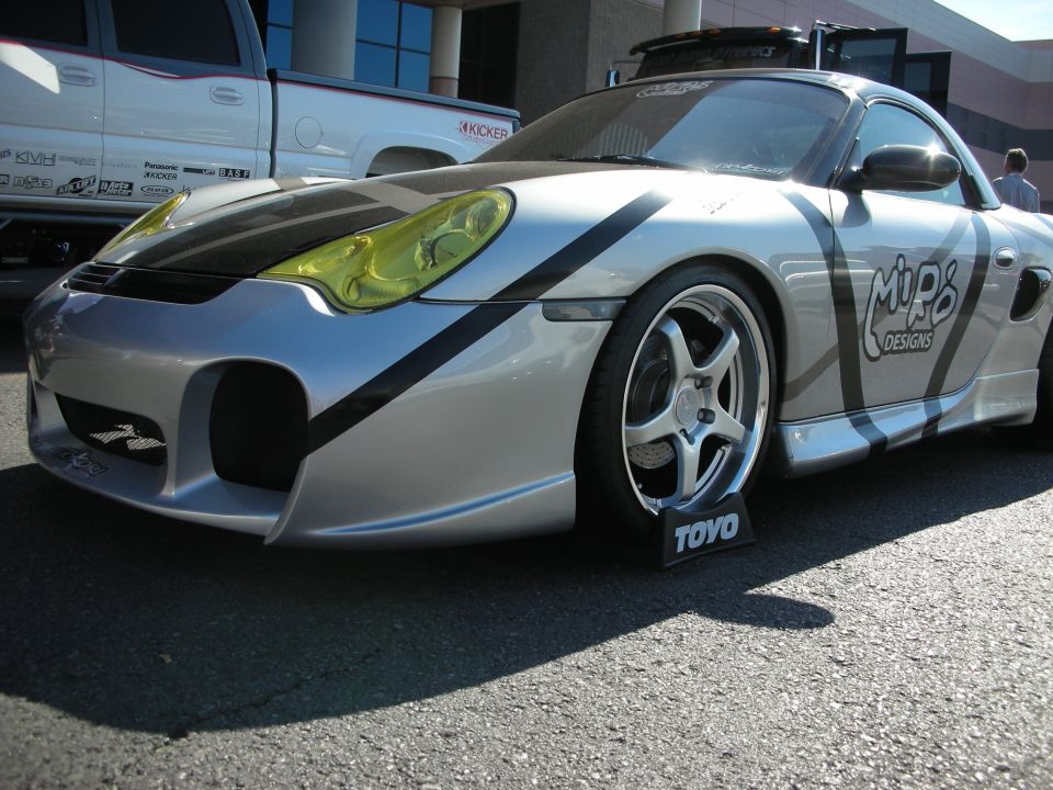 Front of silver Porsche with yellow headlights and Mip6 Designs graphics