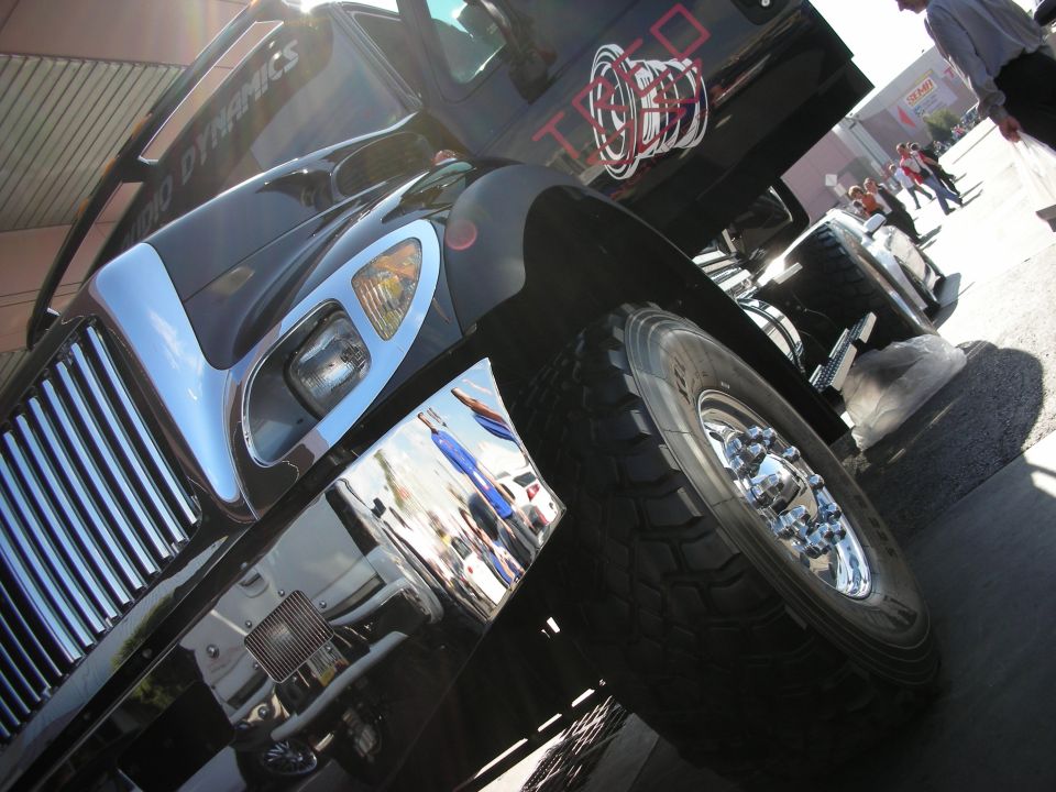 Low-angle shot of black lifted truck front with chrome wheels and big tire