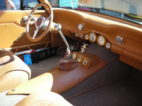 1998 Ford Crown Victoria - custom tan-trimmed dashboard with a chrome steering wheel, round gauges, and a tall shifter inside a hot rod.
