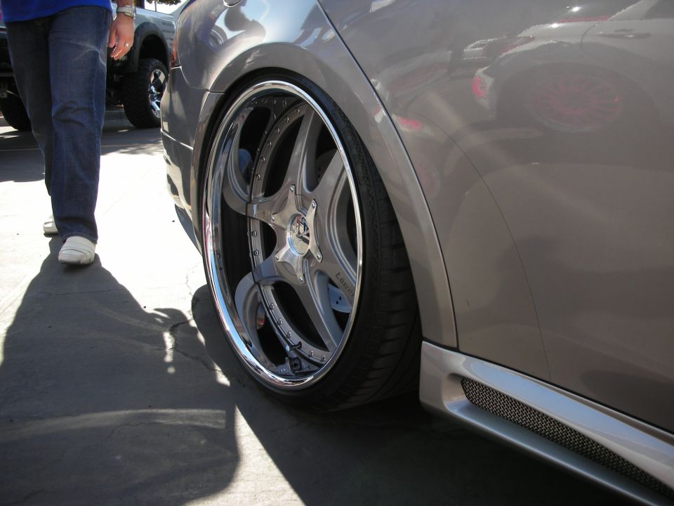 Chrome wheel on a slammed silver car with stretched tire