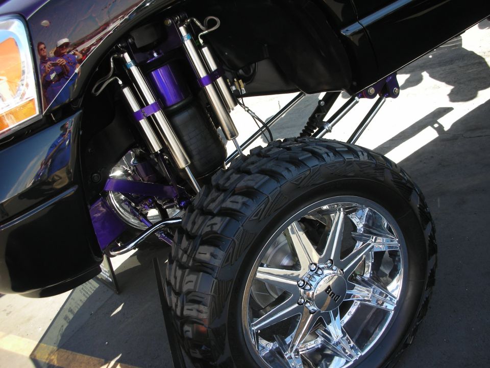 Purple suspension with dual shocks and chrome wheel under a truck