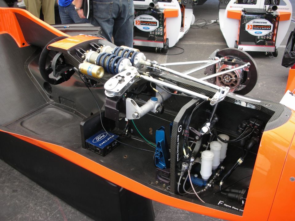 Rear cockpit and engine bay detail of an orange open-wheel race car