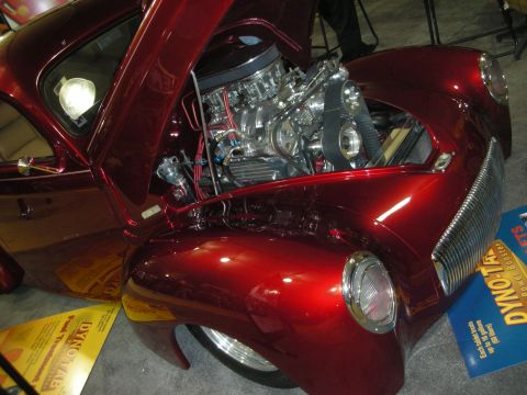1998 Ford Crown Victoria - candy-red vintage hot rod coupe sits with its hood open, revealing a polished supercharged chrome V8 engine.