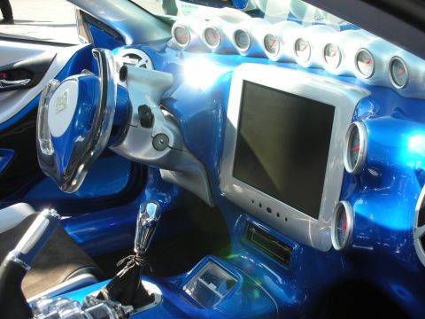 1998 Ford Crown Victoria - custom blue car interior features a row of round gauges, a center LCD screen, and a chrome shifter.
