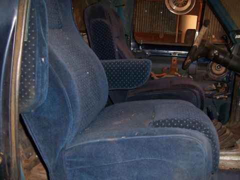 1983 Ford Bronco - Interior of a vehicle with blue velour bucket seats and a partial view of the dashboard.