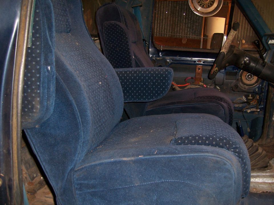 Interior view of a vehicle showing blue velour bucket seats and dashboard