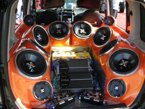 1998 Ford Crown Victoria - car's hatch area is built out with multiple orange-trimmed subwoofers, speakers, and PowerBass amplifiers.