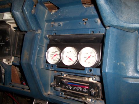 1983 Ford Bronco - Aftermarket gauges for water, volts, and oil are mounted in the dashboard above the vehicle's radio.
