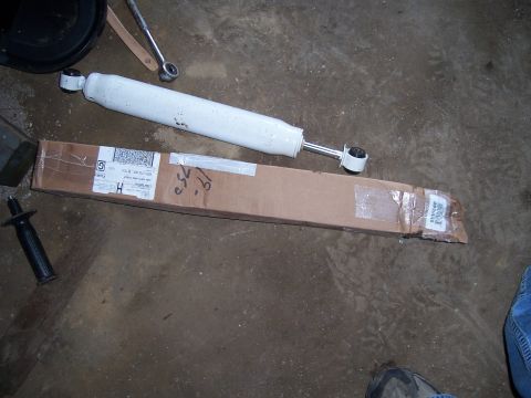 1983 Ford Bronco - A white shock absorber and its shipping box lie on a concrete floor.