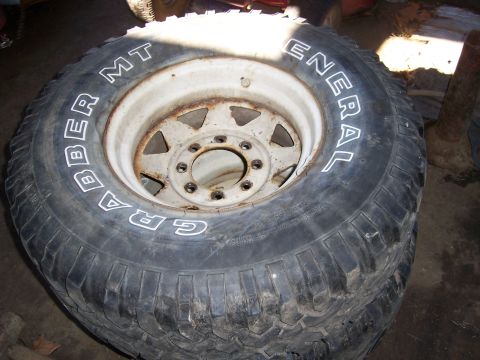 1983 Ford Bronco - A close-up view of a tire and wheel assembly, prominent white lettering on the tire.