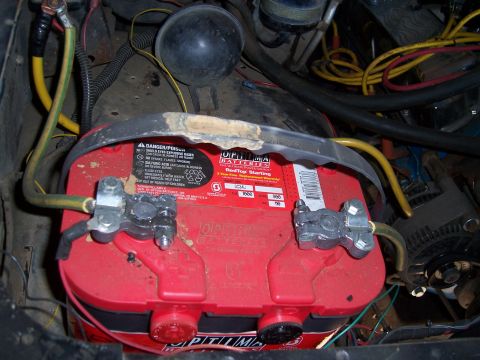 1983 Ford Bronco - Close-up of an Optima RedTop battery with connected cables, part of a vehicle's engine bay.