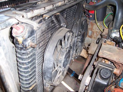 1983 Ford Bronco - Engine bay view of a radiator with electric fans and a serpentine belt system.